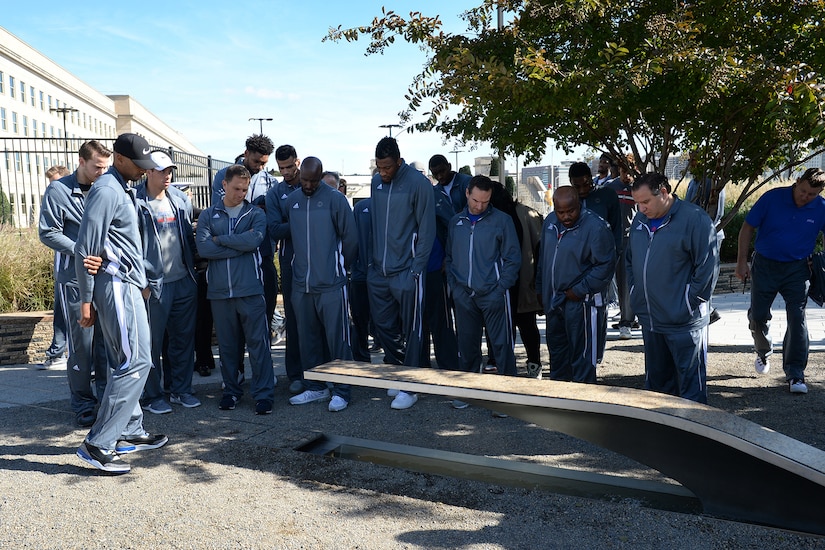 Several men look at inscription on a bench.