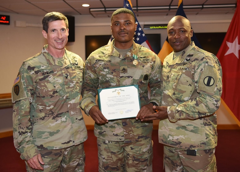 U.S. Army Staff Sgt. Brandon Scarbrough (center), aircraft structural repair instructor, Charlie Company, 2-210 Battalion, 128th Aviation Brigade, receives his award for Fort Eustis’ NCO of the year April 15, 2019. (U.S. Air Force Photo by Senior Amn. Delaney Gonzales)