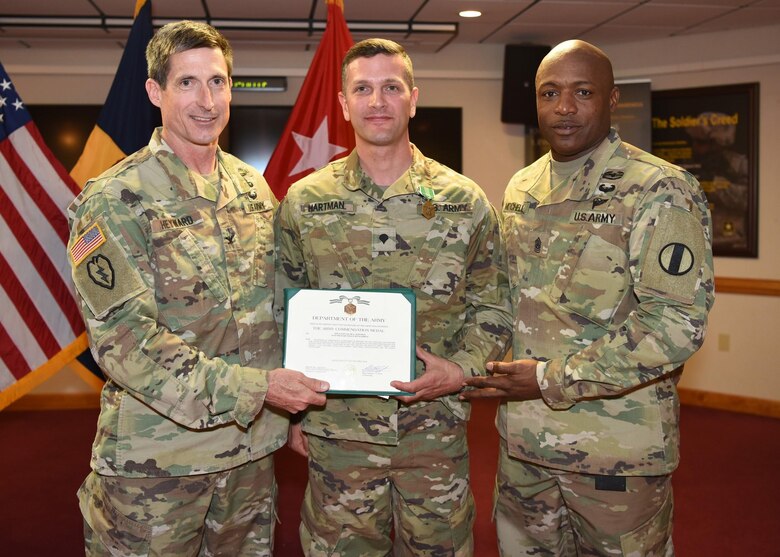 U.S. Army Spc. Jacob A. Hartman (center), military police soldier, 221st military police detachment, U.S. Army Training and Doctrine Command, receives his award for Fort Eustis’ Soldier of the Year April 15, 2019. (U.S. Air Force Photo by Senior Amn. Delaney Gonzalez)