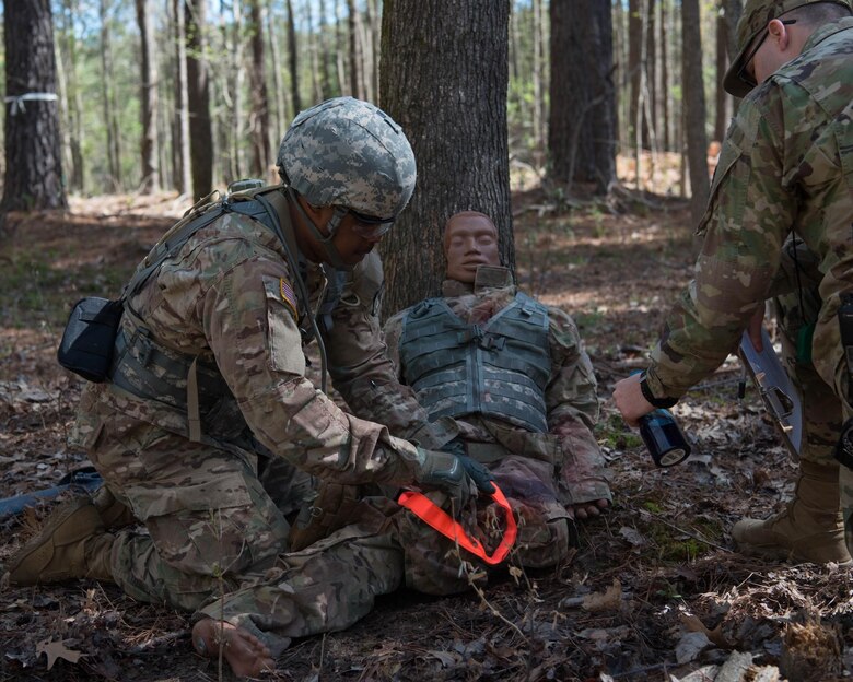 U.S. Army Staff Sgt. Brandon Scarbrough, aircraft structural repair instructor with Charlie Company, 2-210 Battalion, 128th Aviation Brigade, administers medical attention during the NCO/Soldier of the Year competition in Fort Eustis’ Training Area 23 at Joint Base Langley-Eustis, April 10, 2019. This exercise simulated tending to someone who has been wounded in a combat situation. (U.S. Air Force Photo by Airman 1st Class Marcus M. Bullock)