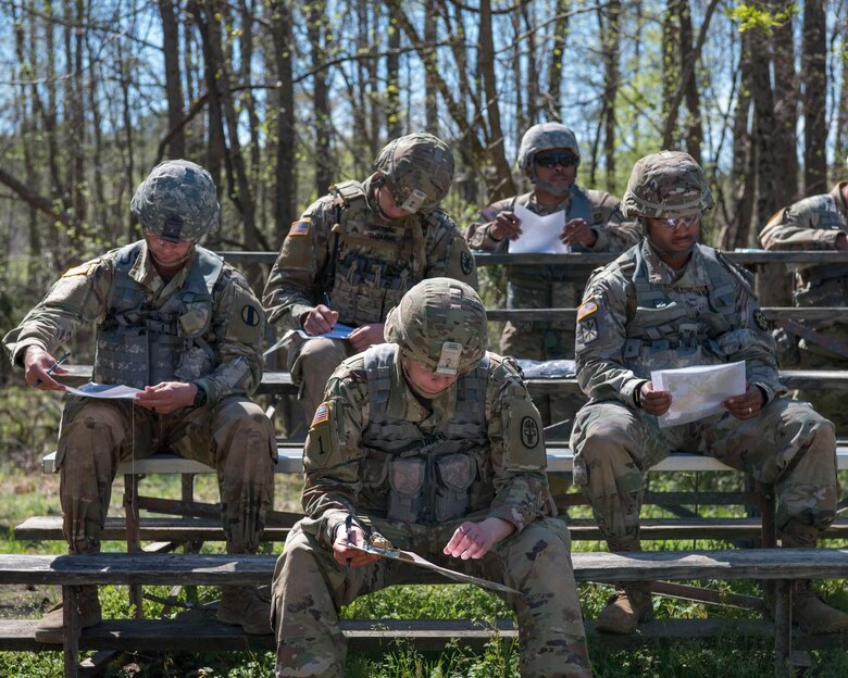 Soldiers competing in the NCO/Soldier of the Year Competition study coordinates for their land navigation portion of the competition in Fort Eustis’ Training Area 23 at Joint Base Langley-Eustis, Virginia, April 10, 2019. The land navigation portion of the competition consisted of daytime and nighttime land navigation.  (U.S. Air Force Photo by Airman 1st Class Marcus M. Bullock)