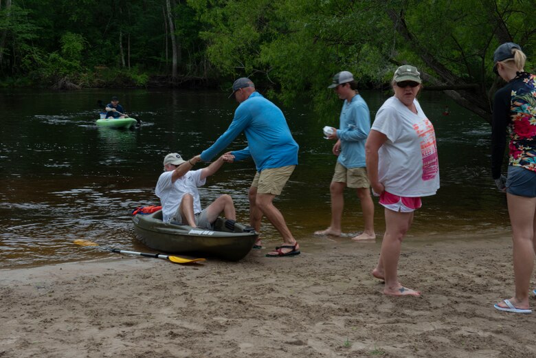 A kayaking instructor helps pull a man from his kayak as he completes a 8 – mile trip, Ridgeville, S.C., April 13, 2019.