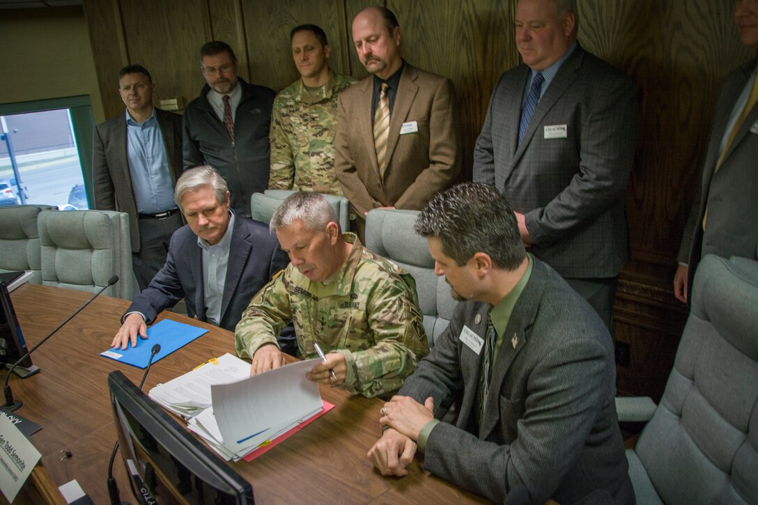 chief of engineers signs papers with senator hoeven and federal and local officials