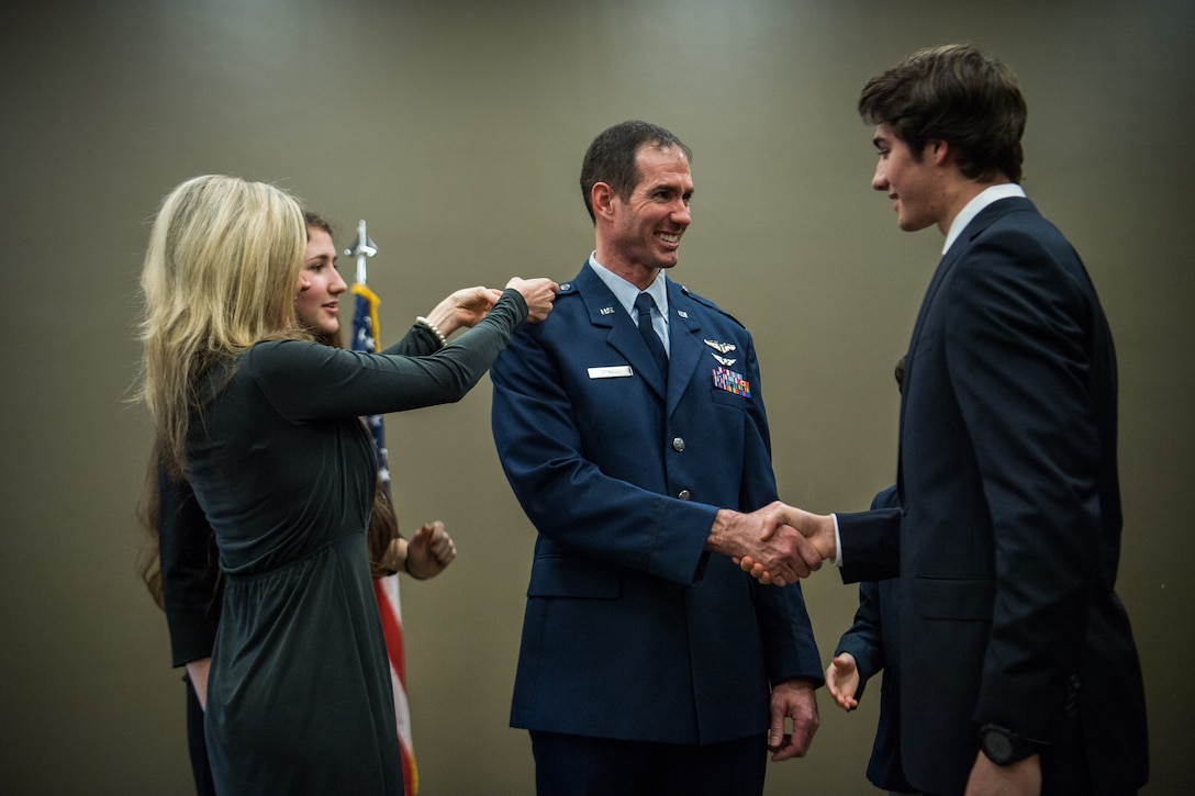 Lt. Col. Christopher Spinelli is joined by his family to assist with pinning on his new rank of Colonel, Mar. 2, 2019, Scott Air Force Base, Illinois during his promotion ceremony. (U.S. Air Force photo by Master Sgt. Christopher Parr)
