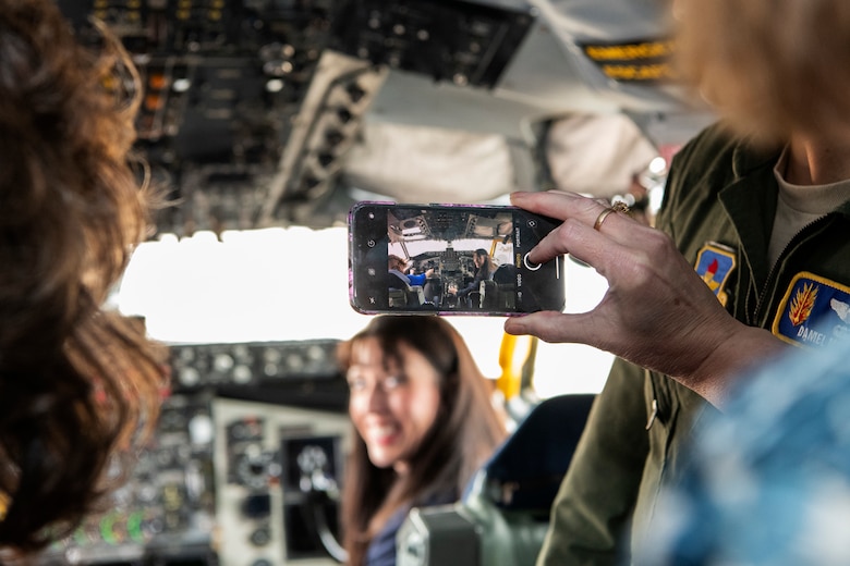 Civilian medical health professional takes photo of woman in copilot KC-135 Stratotanker seat.