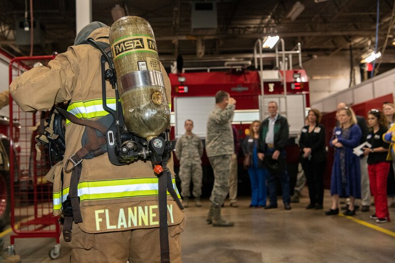 U.S. Air Force firefighter gives crowd demonstration of gear.