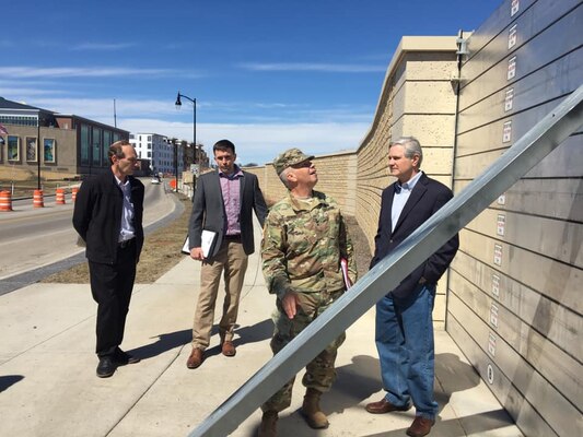 men look at flood wall