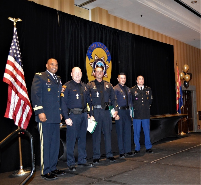 Brig. Gen. Kevin Vereen, deputy commanding general, United States Army Recruiting Command, poses with (from left to right) Sergeant Robert Goddard, Officer Jacob Taylor, Officer Donald Topar and Sgt. 1st Class Todd Miller, station commander, Foothills Recruiting Station, during an award ceremony, April 12, El Conquistador Hilton, Tucson, Ariz. The trio of Goddard, Taylor and Topar, all serving the Oro Valley Police Department, helped save Miller’s life, when he suffered a heart attack in traffic, July 18, 2018. All three were awarded the Army Commander’s Award for Public Service Medal by Vereen for their actions. (U.S. Army Photo by Mike Scheck, USAREC Public Affairs)