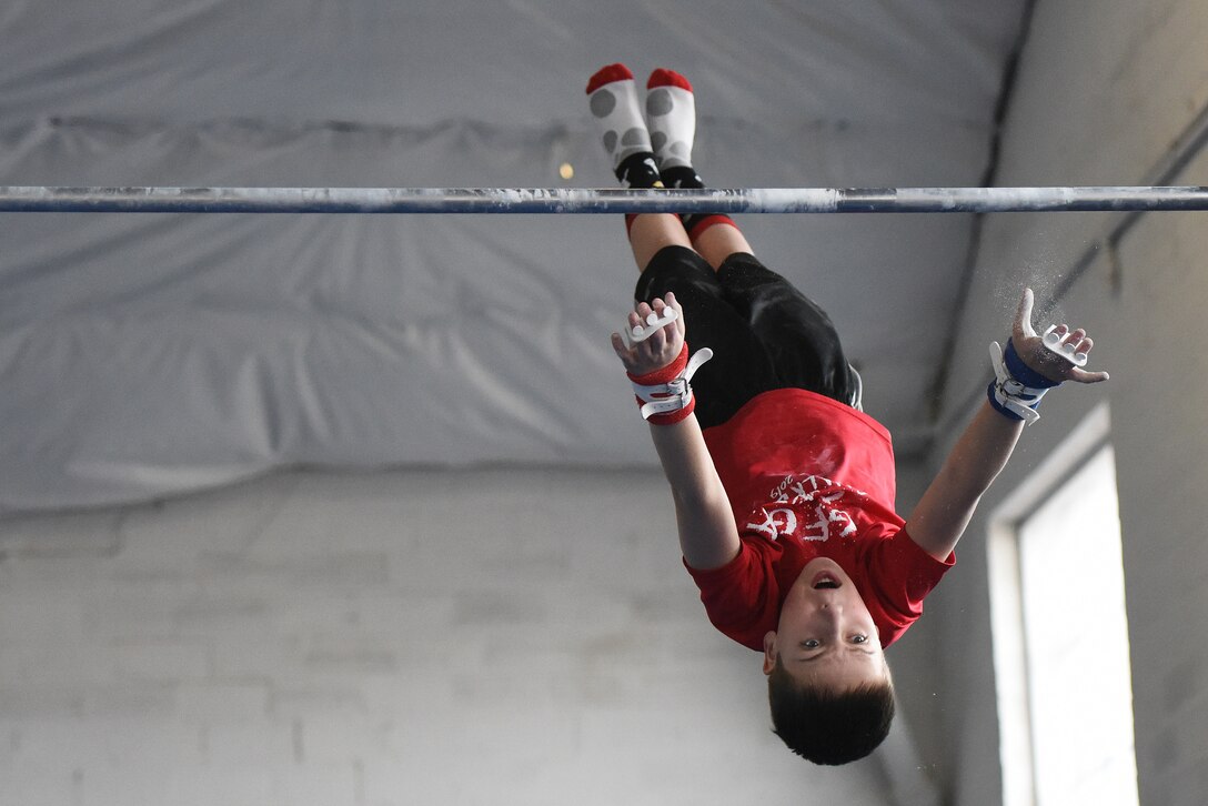 Jonathan Menuey, son of Col. Christopher Menuey, 341st Operations Group, performs a fly away from the horizontal bar April 11, 2019, in Great Falls, Mont.