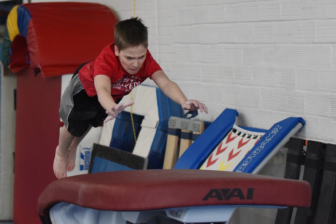 Jonathan Menuey, son of Col. Christopher Menuey, 341st Operations Group, performs a handspring vault April 11, 2019, in Great Falls, Mont.