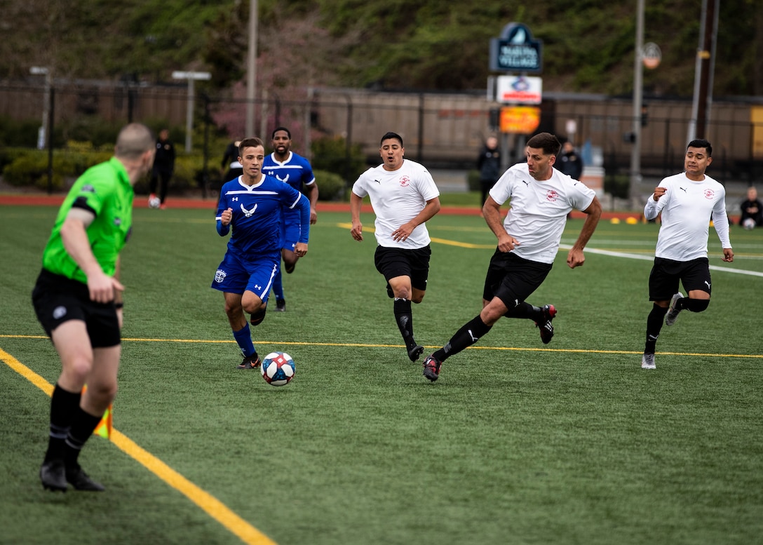 NAVAL STATION EVERETT, Wa. (April 16, 2019) - Players from the Marine Corp soccer team run to defend a drive by the Air Force soccer team at the Armed Forces Sports Men’s Soccer Championship hosted at Naval Station Everett. (U.S. Navy Photo by Mass Communication Specialist 2nd Class Ian Carver/RELEASED).