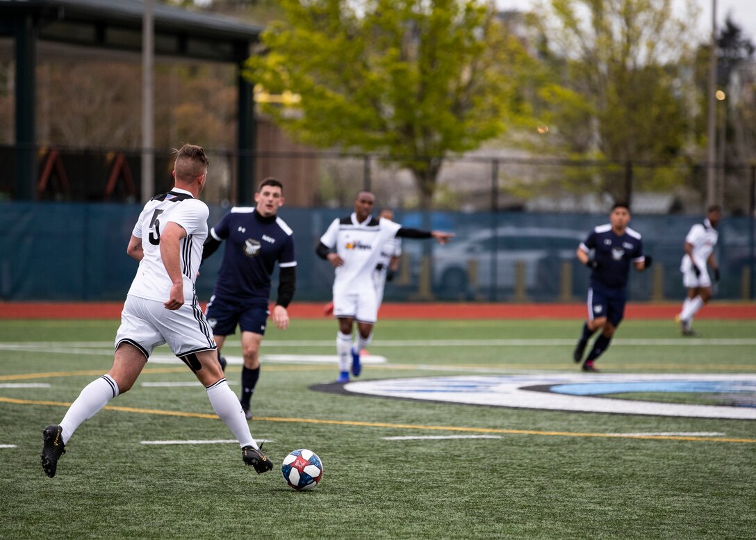 NAVAL STATION EVERETT, Wa. (April 16, 2019) - 1st Lt. Taner Vosuick, stationed at Fort Hood, Tx.,  from the Army soccer team drives the ball against players from the Navy soccer team during a second round match of the Armed Forces Sports Men’s Soccer Championship hosted at Naval Station Everett. (U.S. Navy Photo by Mass Communication Specialist 2nd Class Ian Carver/RELEASED).