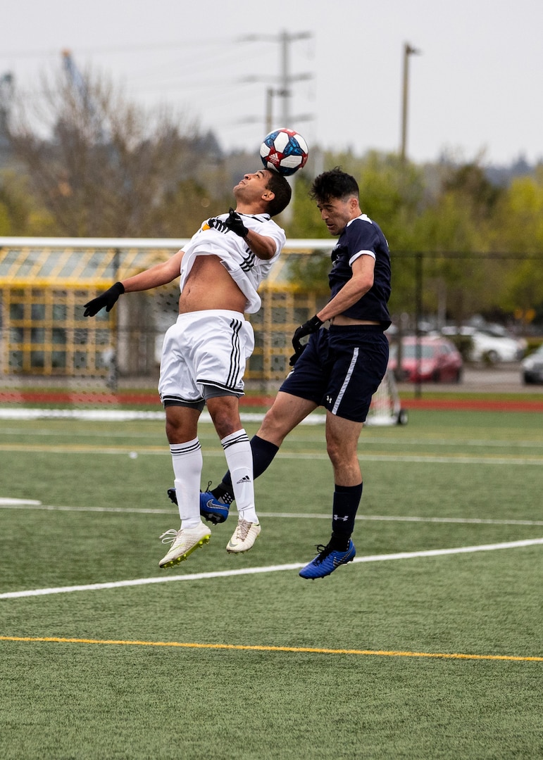 NAVAL STATION EVERETT, Wa. (April 16, 2019) - Sgt. Allyn Wilson, stationed at Fort Meade, Md., from the Army soccer team heads the ball away from Lt. j.g. Alexander Maney, stationed at Norfolk, Va., from the Navy soccer team during a second round match of the Armed Forces Sports Men’s Soccer Championship hosted at Naval Station Everett. (U.S. Navy Photo by Mass Communication Specialist 2nd Class Ian Carver/RELEASED).