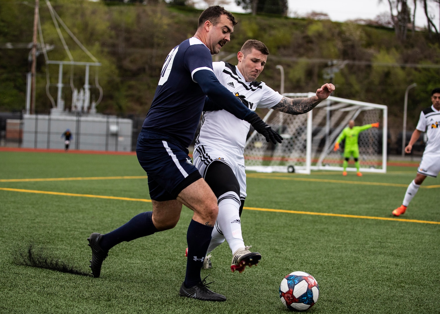 NAVAL STATION EVERETT, Wa. (April 16, 2019) - Petty Officer Michael Williams, stationed at Naval Construction Battalion Center Gulfport, MS., from the Navy soccer team drives the ball against 1st Lt. Andrew Stames, stationed at Fort Bragg, NC., from the Army soccer team during a second round match of the Armed Forces Sports Men’s Soccer Championship hosted at Naval Station Everett. (U.S. Navy Photo by Mass Communication Specialist 2nd Class Ian Carver/RELEASED).