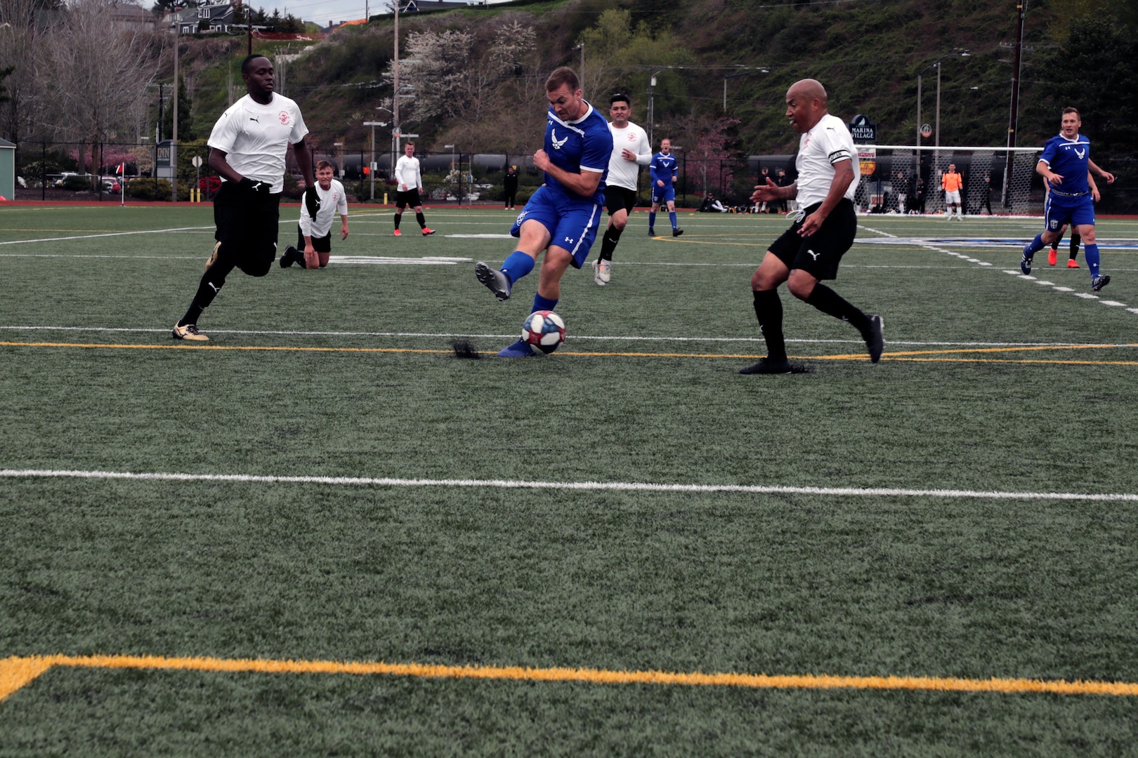 NAVAL STATION EVERETT, Wash.  (April 14, 2019) Air Force Capt. Andrew Belk (blue center) scores his first of two goals during the match versus Marine Corps during the 2019 Armed Forces Men's Soccer Championship held at Naval Station Everett, Wash. from 14-20 April, featuring Service members from the Army, Marine Corps, Navy (including Coast Guard) and Air Force. (U.S. Navy photo by MC2 Ian Carver/Released)