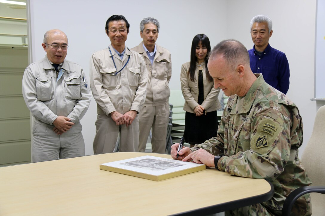 USACE Deputy Commanding General Maj. Gen. Wehr signs an framed  issue of the Bamboo Bridge for the Yokosuka Resident Office.