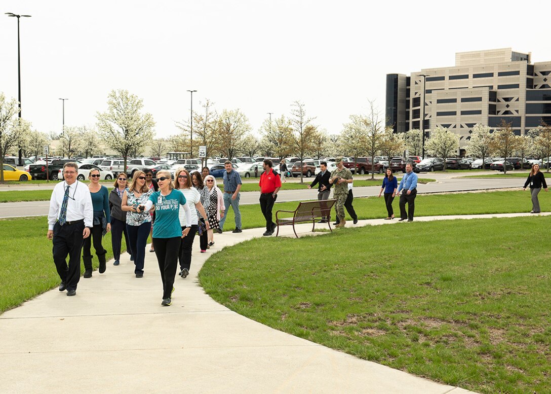 Group of people walk on park sidewalk