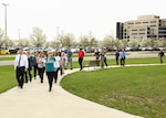 Group of people walk on park sidewalk