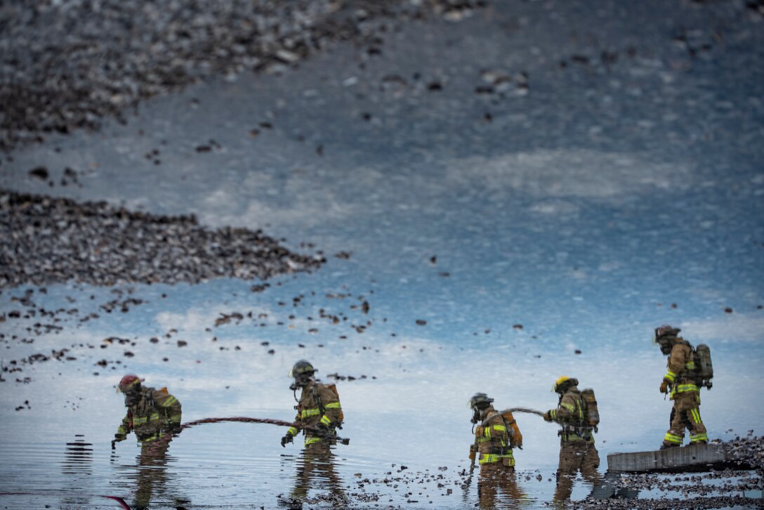 Sheppard Air Force Base firefighters rush to put a fire out at Sheppard AFB, Texas, April 17, 2018. The department conducts frequent training sessions to refresh different proficiencies required of firefighters including battling exterior and interior aircraft fires as well as engine fires. (U.S. Air Force photo by Airman 1st Class Pedro Tenorio)