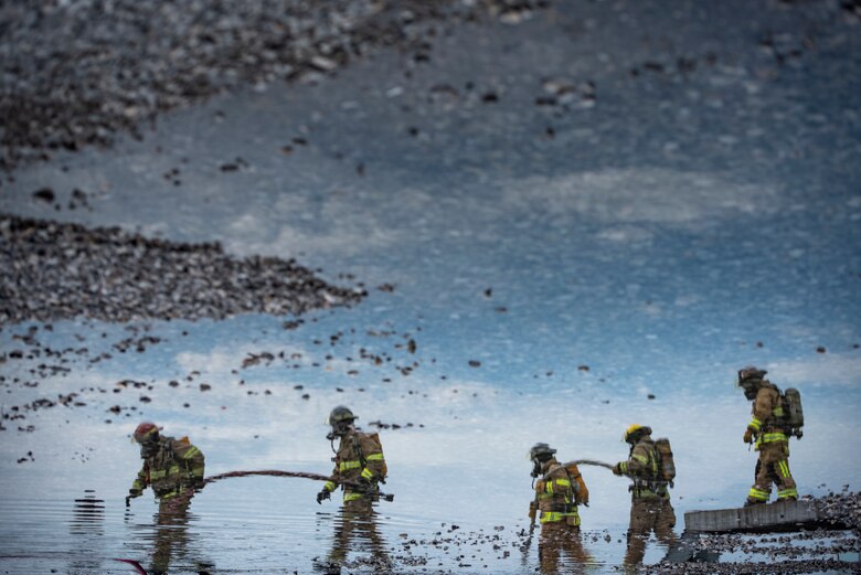 Sheppard Air Force Base firefighters rush to put a fire out at Sheppard AFB, Texas, April 17, 2018. The department conducts frequent training sessions to refresh different proficiencies required of firefighters including battling exterior and interior aircraft fires as well as engine fires. (U.S. Air Force photo by Airman 1st Class Pedro Tenorio)