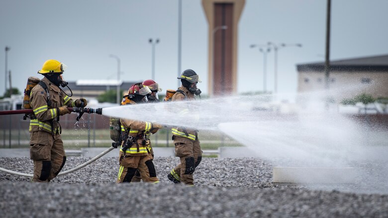 Sheppard Air Force Base firefighters rush to put a fire out at Sheppard AFB, Texas, April 17, 2018. The department conducts frequent training sessions to refresh different proficiencies required of firefighters including battling exterior and interior aircraft fires as well as engine fires. (U.S. Air Force photo by Airman 1st Class Pedro Tenorio)