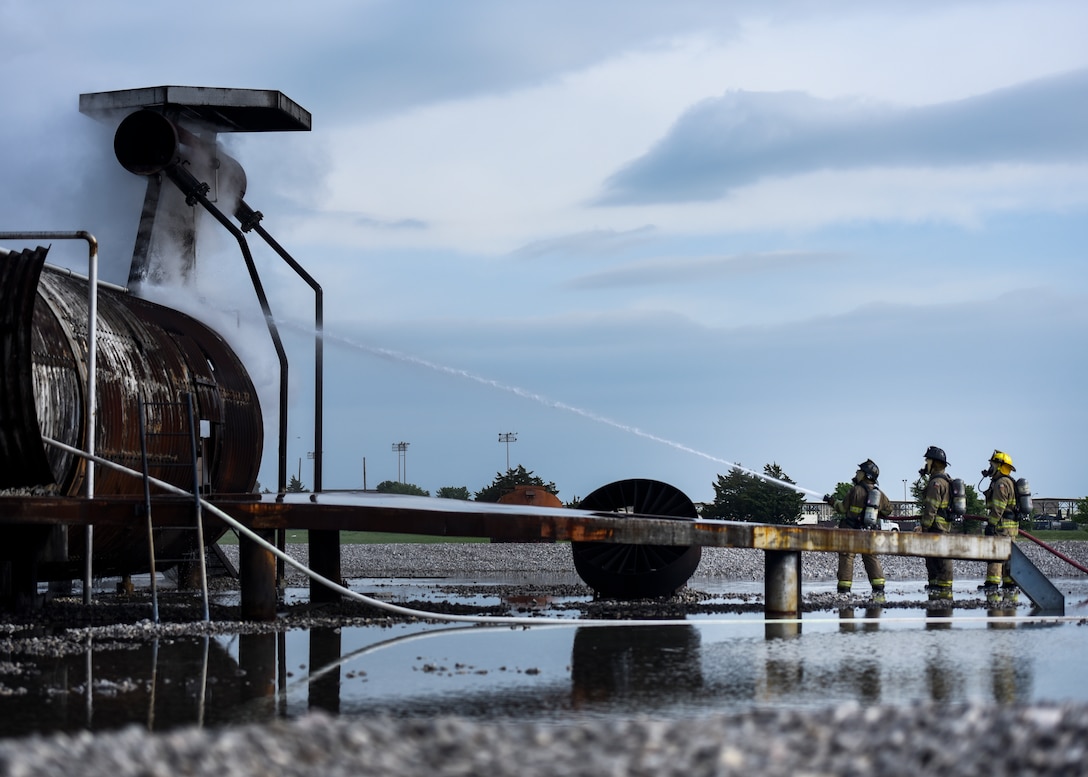 Sheppard Air Force Base firefighters rush to put a fire out at Sheppard AFB, Texas, April 17, 2018. The department conducts frequent training sessions to refresh different proficiencies required of firefighters including battling exterior and interior aircraft fires as well as engine fires. (U.S. Air Force photo by Airman 1st Class Pedro Tenorio)