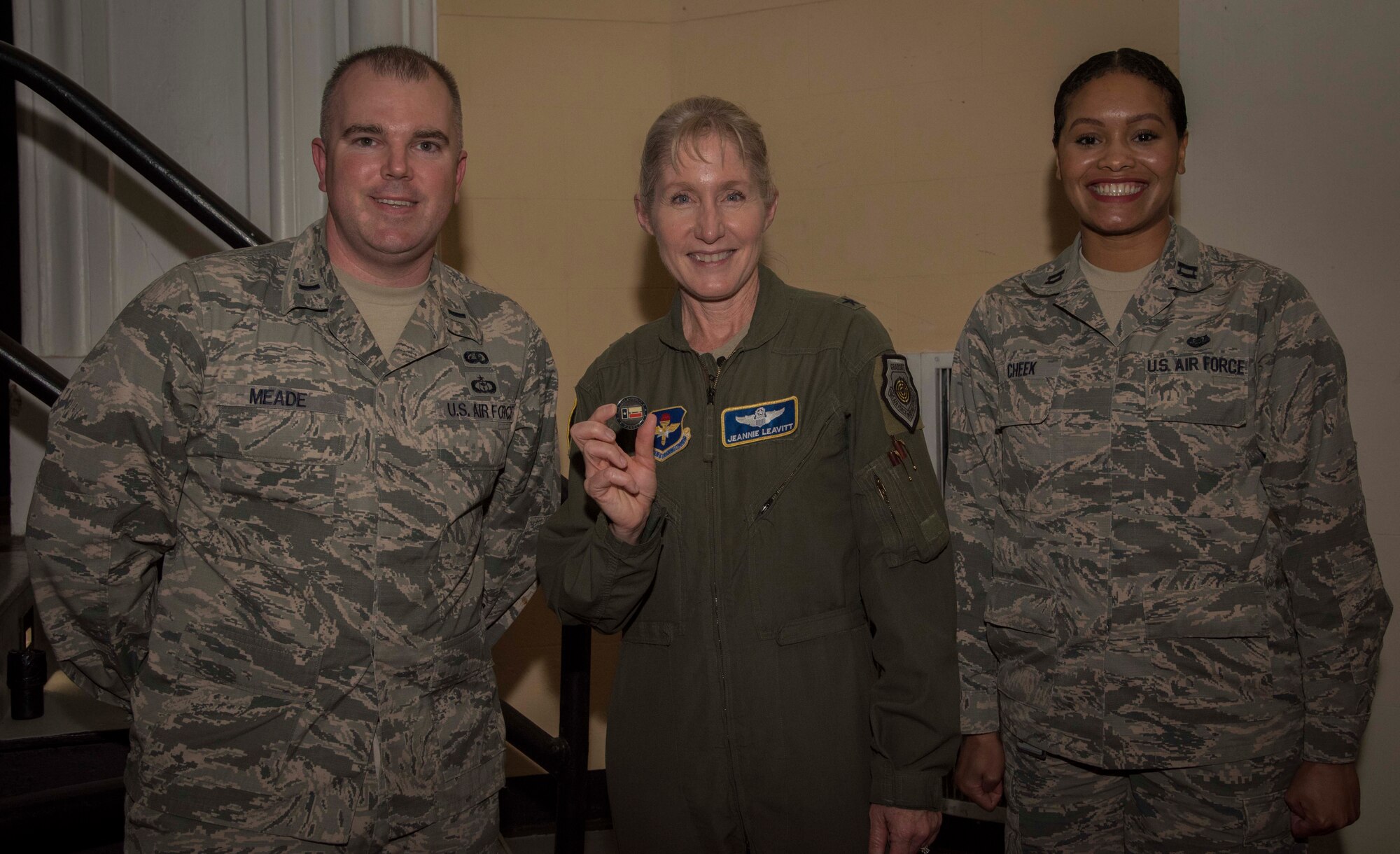 First Lt. Kiely Meade, officer in charge of Transitions Operations Headquarters Air Force Personnel Center, and Capt. Dayna Cheek, chief of adverse actions, 502d Security Forces Group, pose with Brig. Gen. Jeannie Leavitt, commander of Air Force Recruiting Service, April 10, 2019, in the Fleenor Auditorium, Joint Base San Antonio-Randolph, after they coined her. The purpose of this event was to provide an opportunity for the JBSA community to hear, ask questions and learn from a leader like Brig. Gen. Leavitt as she shares her story as the first female fighter pilot and the first woman to command an Air Force combat fighter wing and talks about effective leadership practices in the Air Force. (U.S. Air Force photo by: Airman 1st Class Shelby Pruitt)