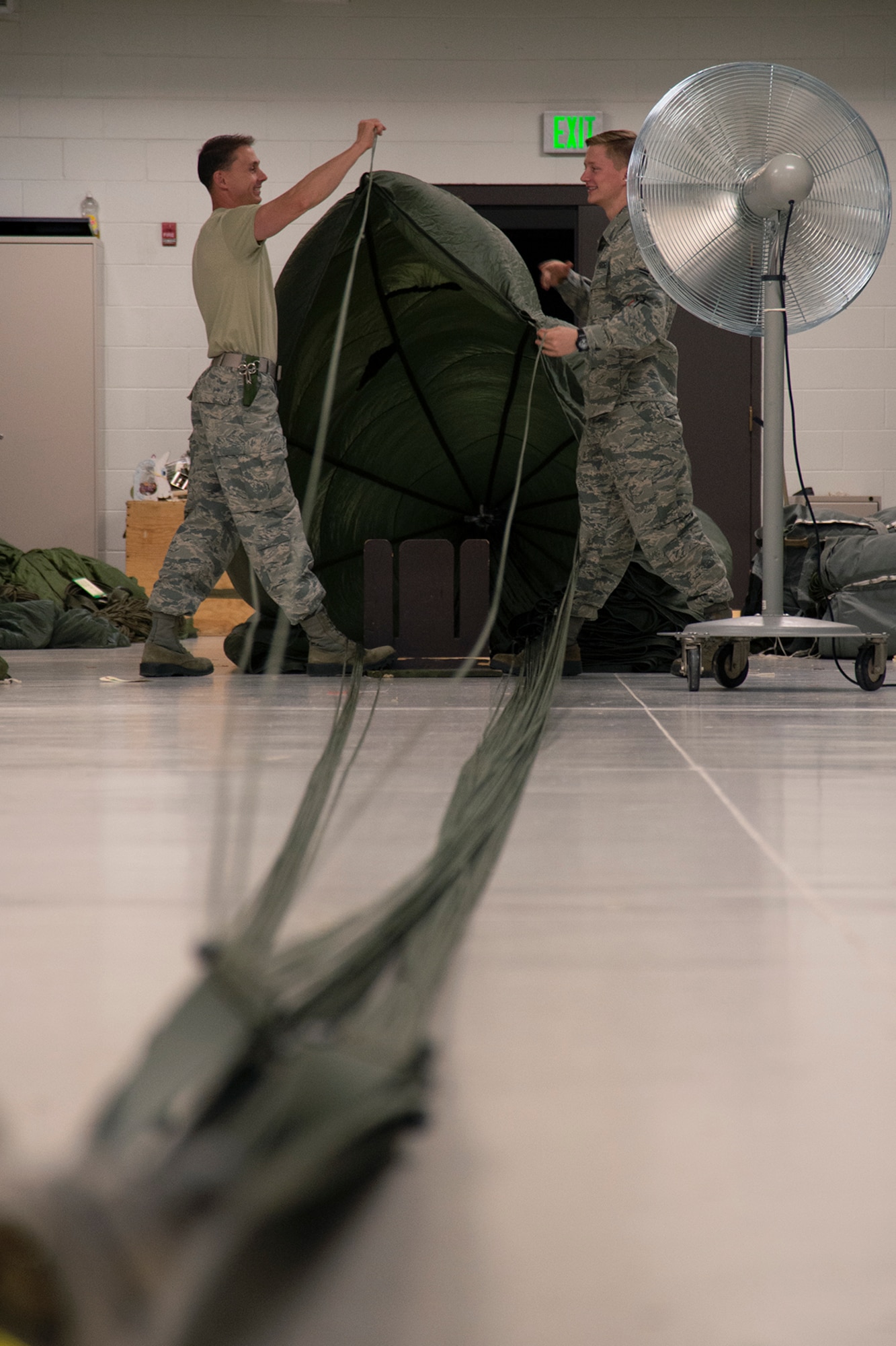 Senior Airman Will Lipscomb, left, and Airman 1st Class Tyler Pitts, both 39th Aerial Port Squadron air transportation technicians, practice inspecting a G-12 parachute at Peterson Air Force Base, Colorado, April 16, 2019. The