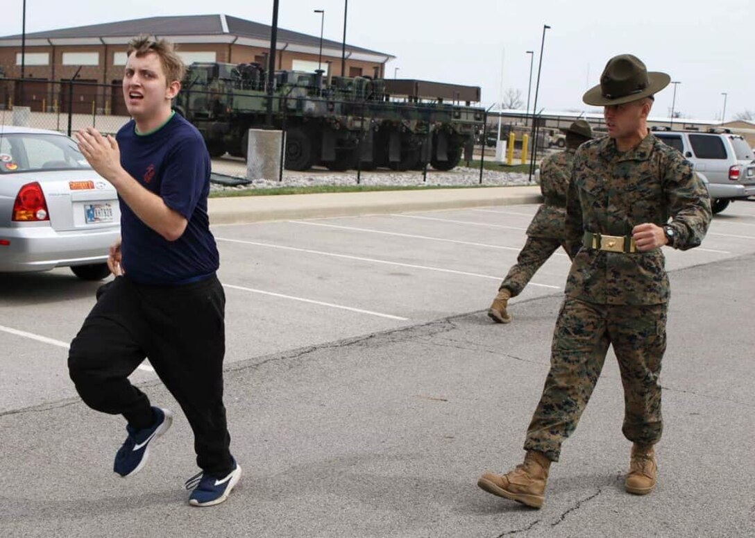 Sergeant Matthew Schihl, a drill instructor with Marine Corps Recruit Depot San Diego, California, motivates a poolee to run faster during the combat fitness test at an all-hands pool function. Recruiting Station Indianapolis hosted the pool function to simulate recruit training, while preparing  the poolees to deal with the stress and high tempo during the 13-week training regimen. (Official U.S. Marine Corps photo by Sgt. Carl King/Released)