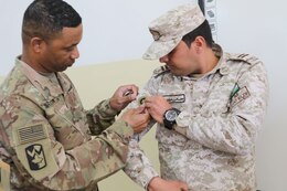 U.S. Army Sgt. Maj. Marvin Martin, 1st Theater Sustainment Command (1TSC) strategic operations and plans noncommissioned officer in charge, presents the Jordan Armed Forces NCO Academy command sergeant major with a 1TSC patch during a non-commissioned officer subject matter expert exchange at the JAF Noncommissioned Officer Academy April 10, 2019. The U.S. and Jordan remain committed to a strong bilateral relationship built on shared interests and mutual respect, and the exchange focused on increasing interoperability while also identifying feasible, long-term solutions for developing JAF noncommissioned officers and improving training at the JAF NCOA.