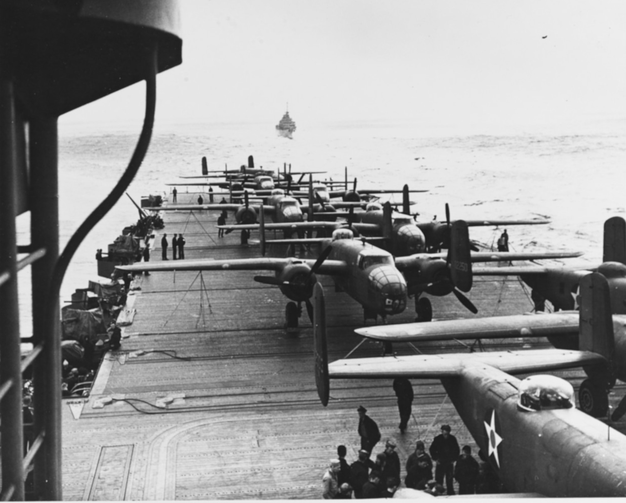 On 18 April 1942, airmen of the US Army Air Forces, led by Lt. Col. James H. (Jimmy) Doolittle, carried the Battle of the Pacific to the heart of the Japanese empire with a surprising and daring raid on military targets at Tokyo, Yokohama, Yokosuka, Nagoya, and Kobe. This heroic attack against these major cities was the result of coordination between the Army Air Forces and the US Navy, which carried the sixteen North American B-25 medium bombers aboard the carrier USS Hornet to within take-off distance of the Japanese Islands. Here, a pair of alert escorts follow the USS Hornet to protect her lethal cargo of B-25 bombers. The aircraft carrier Hornet had 16 AAF B-25s on deck, ready for the Tokyo Raid.(U.S. Air Force photo)