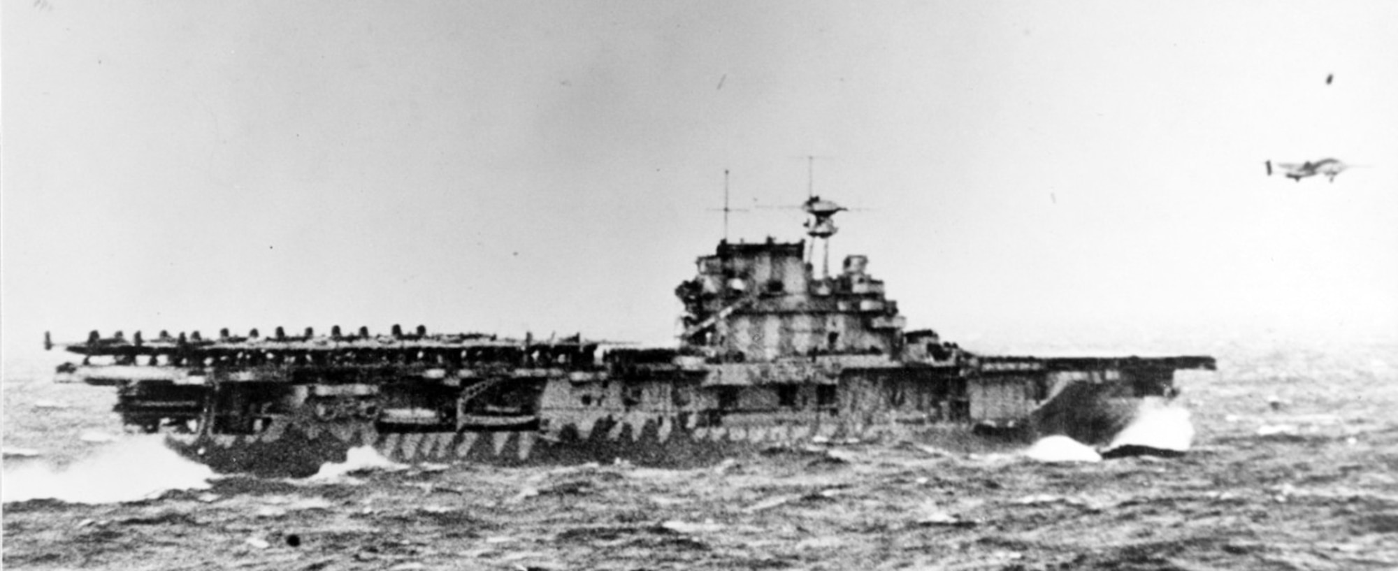 The USS Hornet, a U.S. Navy vessel, launches Doolittle's force at the start of the first U.S. air raid on the Japenese home lands. On 18 April 1942, airmen of the US Army Air Forces, led by Lt. Col. James H. (Jimmy) Doolittle, carried the Battle of the Pacific to the heart of the Japanese empire with a surprising and daring raid on military targets at Tokyo, Yokohama, Yokosuka, Nagoya, and Kobe. This heroic attack against these major cities was the result of coordination between the Army Air Forces and the US Navy, which carried the sixteen North American B-25 medium bombers aboard the carrier USS Hornet to within take-off distance of the Japanese Islands. Here, a pair of alert escorts follow the USS Hornet to protect her lethal cargo of B-25 bombers. (Courtesy Photo)