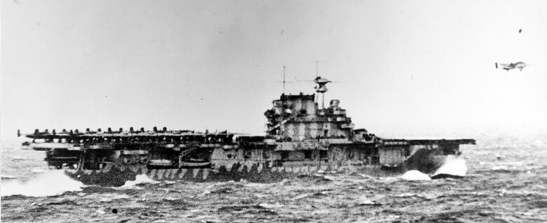The USS Hornet, a U.S. Navy vessel, launches Doolittle's force at the start of the first U.S. air raid on the Japenese home lands. On 18 April 1942, airmen of the US Army Air Forces, led by Lt. Col. James H. (Jimmy) Doolittle, carried the Battle of the Pacific to the heart of the Japanese empire with a surprising and daring raid on military targets at Tokyo, Yokohama, Yokosuka, Nagoya, and Kobe. This heroic attack against these major cities was the result of coordination between the Army Air Forces and the US Navy, which carried the sixteen North American B-25 medium bombers aboard the carrier USS Hornet to within take-off distance of the Japanese Islands. Here, a pair of alert escorts follow the USS Hornet to protect her lethal cargo of B-25 bombers. (Courtesy Photo)