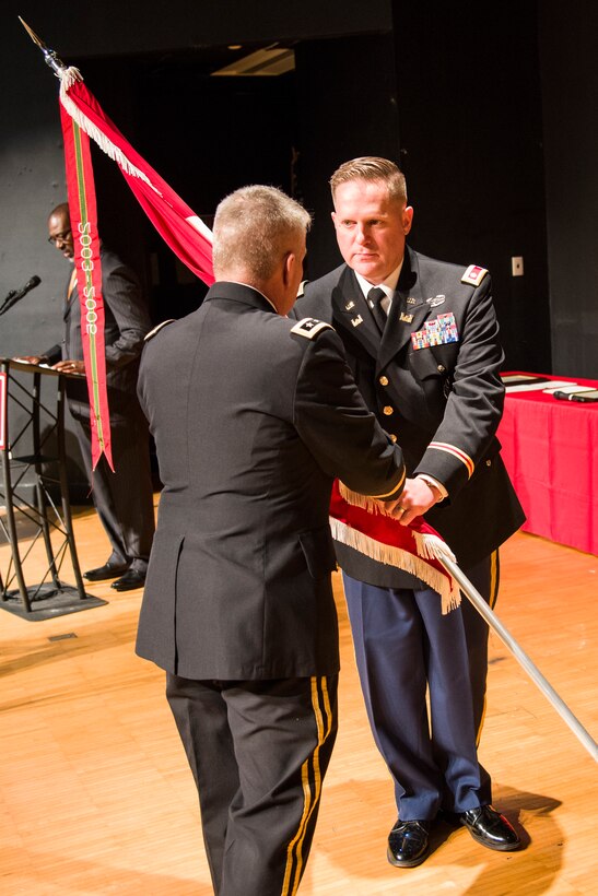 Lt. Gen. Todd Semonite (at left), chief of engineers and commanding general of the U.S. Army Corps of Engineers, passes the Huntsville Center colors to Lt. Col. H. W. Hugh Darville, Huntsville Center's incoming commander, during a change-of-command ceremony April 18, 2019, at the University of Alabama in Huntsville's Chan Auditorium in Huntsville, Alabama.