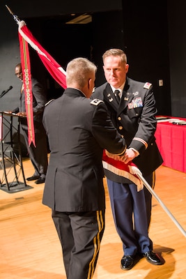 Lt. Gen. Todd Semonite (at left), chief of engineers and commanding general of the U.S. Army Corps of Engineers, passes the Huntsville Center colors to Lt. Col. H. W. Hugh Darville, Huntsville Center's incoming commander, during a change-of-command ceremony April 18, 2019, at the University of Alabama in Huntsville's Chan Auditorium in Huntsville, Alabama.