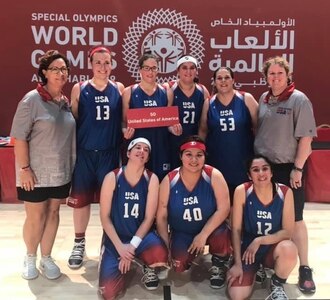 Joint Base San Antonio-Fort Sam Houston Army & Air Force Exchange Service associate Jamie Holt (back row, holding sign) recently returned from competing in the Special Olympics World Games in Abu Dhabi as a member of the U.S. women’s basketball team.