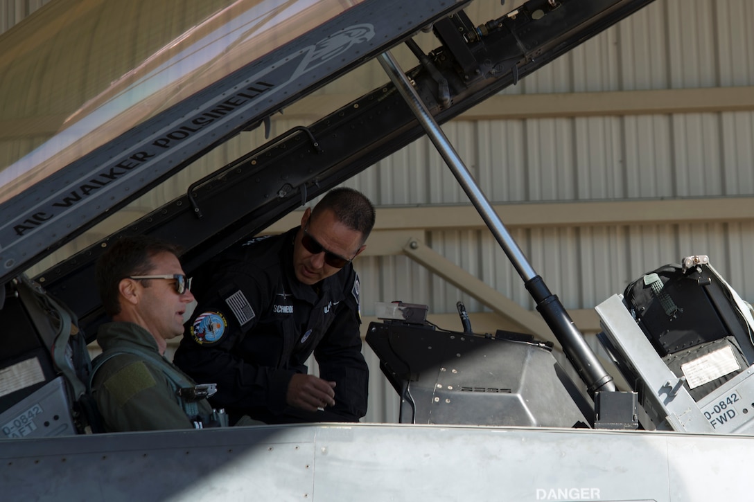 U.S. Air Force Master Sgt. Chris Schneider, F-16 Viper Demonstration Team superintendent, back, helps Townsend Bell, sports commentator and professional race car driver, prepare for flight at Shaw Air Force Base, S.C., April 16, 2019.