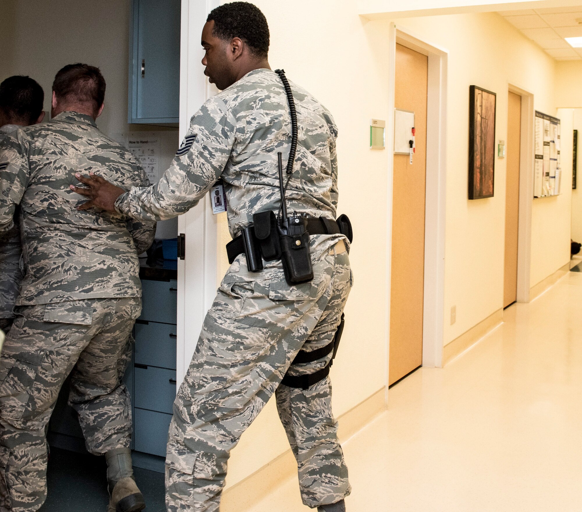 Tech.Sgt. Timothy Wright, 374th Dental Squadron dental hygienist, directs people in a hallway to evacuate to a shelter during an active shooter exercise at Yokota Air Base, Japan, April 18, 2019.
