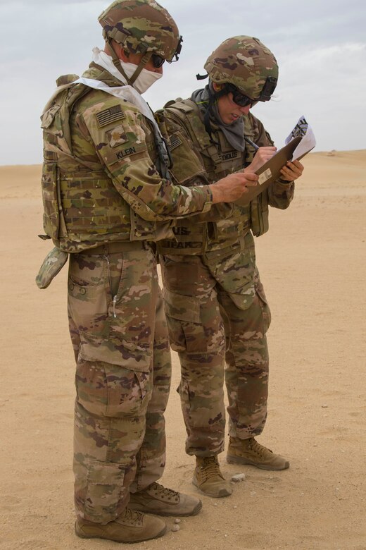 Army Staff Sgt. Danielle Reynolds, right, 637th Chemical, Biological, Radiological and Nuclear Company, reviews her scores with Army Maj. Trevor Klein, 34th Infantry Division, Minnesota Army National Guard, after firing a Beretta M9 during the range qualification event of the German Armed Forces Badge (GAFB) for Military Proficiency on April 9, 2019, at Udairi Range, Kuwait. During this event, participants stand and shoot a total of five rounds with a Beretta M9 at three silhouettes. Participants, who must hit each target at a minimum, shoot in order at targets one, two, three, one, two and earn bronze with three hits, silver for four hits and gold for five hits. U.S. Army Central hosts events such as the GAFB to enhance service member’s personal abilities to stay combat ready which improves overall capabilities.