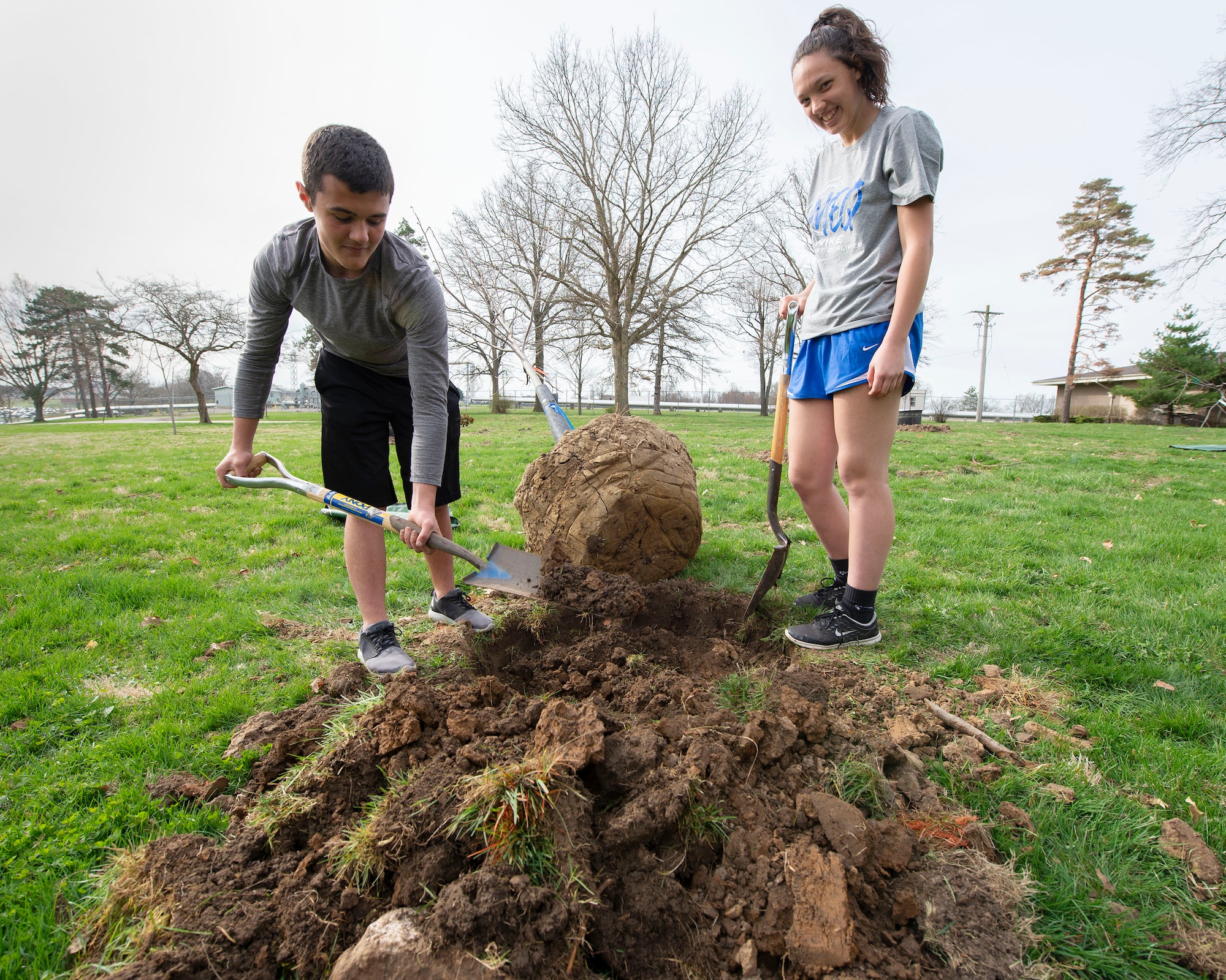Collin Amon (left) and LeeAnn Williams, Fairborn High School advanced placement environmental science students, prepare the soil for planting a redbud tree as part of the 88th Civil Engineer Group and the National Park Service volunteer efforts for Arbor Day on the grounds near the Wright Brothers Memorial, Dayton, Ohio, April 11, 2019. The students volunteered their support efforts in honor of Arbor Day, an annual holiday for the planting of trees, observed throughout the nation. (U.S. Air Force photo by Michelle Gigante)