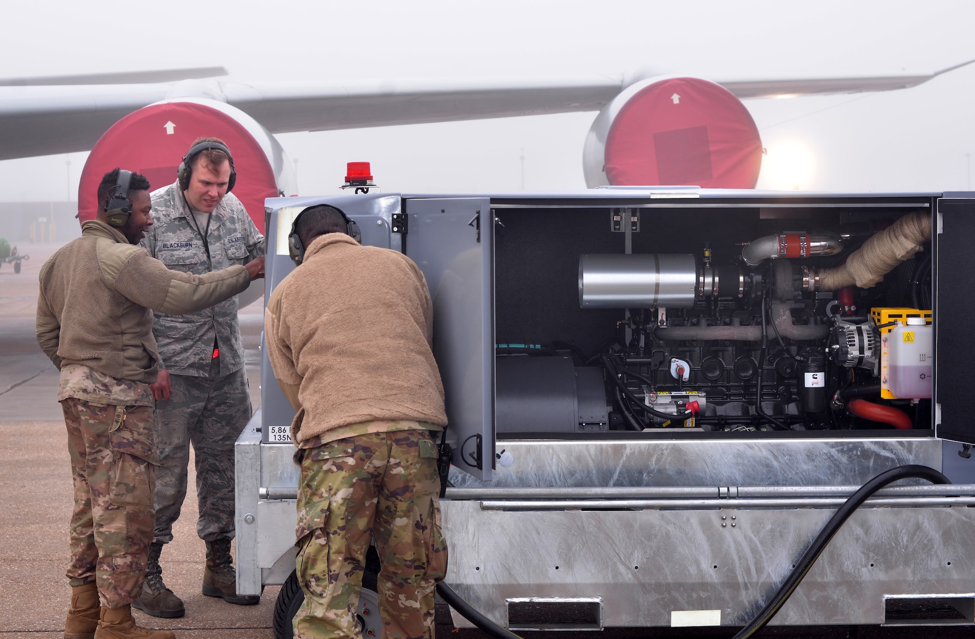 Staff Sgt. David Blackburn, 55th Maintenance Squadron aerospace ground equipment (AGE) journeyman, center, and other AGE personnel, look over recently acquired generators on Offutt AFB, Nebraska. (U.S. Air Force photo by D.P. Heard)