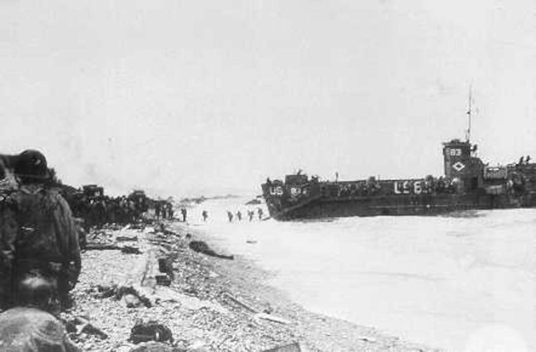 Coast Guard LCI(L)-83 disembarks troops at Omaha Beach, D-Day, 6 June 1944. She struck a mine upon landing and lay disabled on the beach, under enemy fire, until her hull was patched and she was able to get underway.