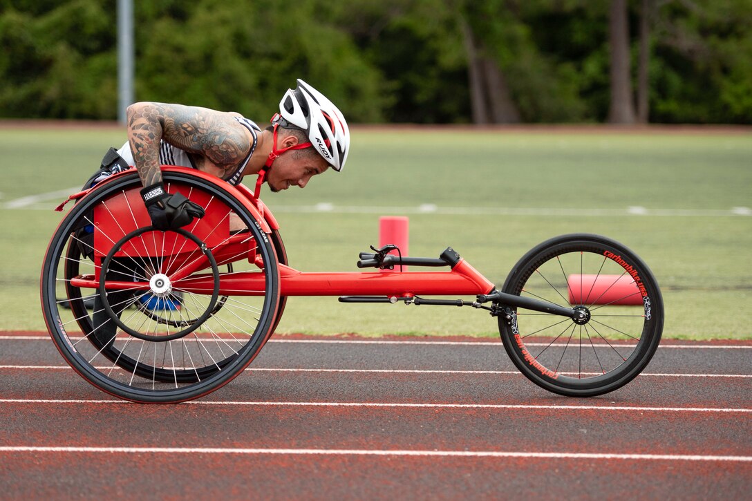 An athlete steers a handcycle on a track.