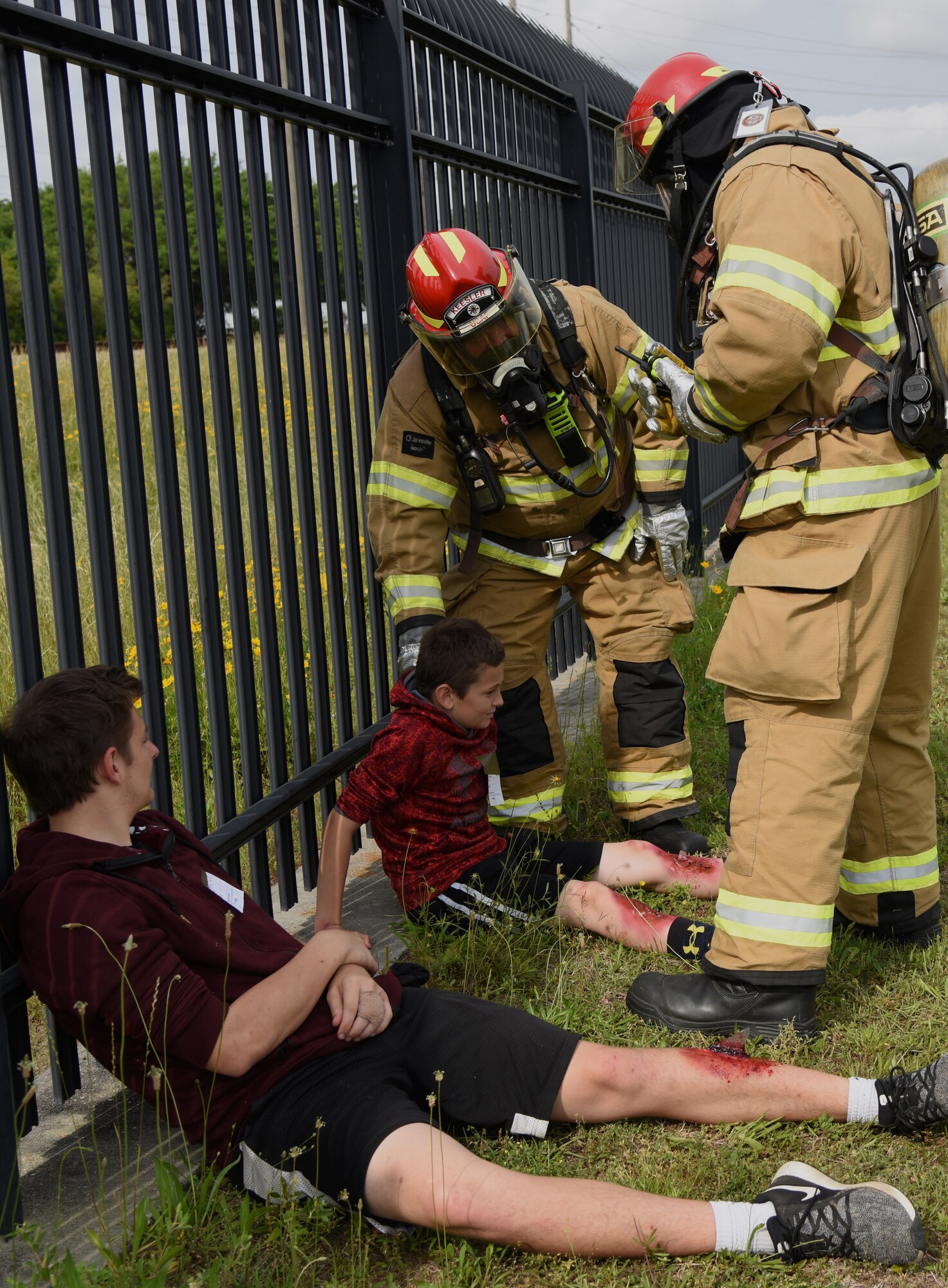 Keesler firefighters inspect injuries on "victims", Eli and Trevyn Perone, sons of U.S. Air Force Master Sgt. Tiffany Satterwhite, 81st Training Wing inspection team member, during a mass casualty and response exercise on Keesler Air Force Base, Mississippi, April 17, 2019. The scenario for the two-day event included a simulated plane crash with debris landing both on and off base in crowds of people. The exercise tested base and local civilian emergency response organizations' ability to operate in a multi-agency and multi-jurisdiction crisis situation. (U.S. Air Force photo by Kemberly Groue)