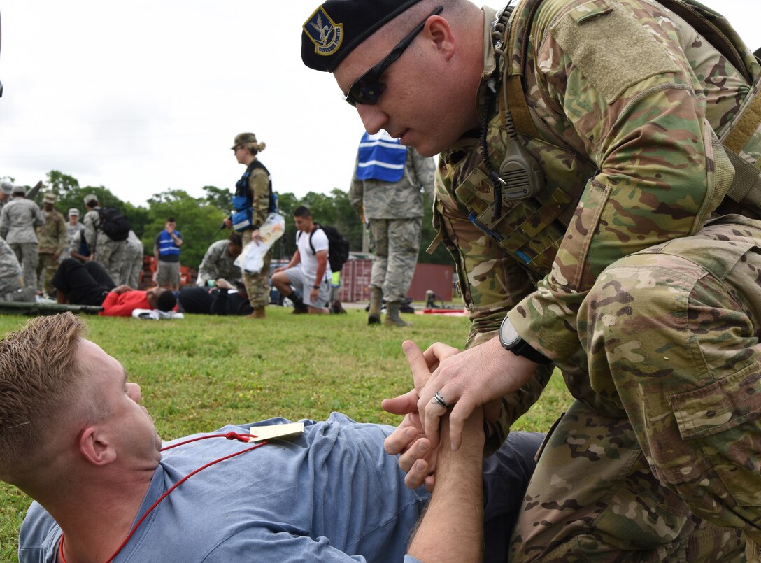 U.S. Air Force Tech. Sgt. Jared Miller 81st Security Forces Squadron flight sergeant, provides medical assistance to Staff Sgt. Colton Monnin, 81st Medical Operations Squadron medical technician, as he portrays a "victim" during a mass casualty and response exercise on Keesler Air Force Base, Mississippi, April 17, 2019. The scenario for the two-day event included a simulated plane crash with debris landing both on and off base in crowds of people. The exercise tested base and local civilian emergency response organizations' ability to operate in a multi-agency and multi-jurisdiction crisis situation. (U.S. Air Force photo by Kemberly Groue)