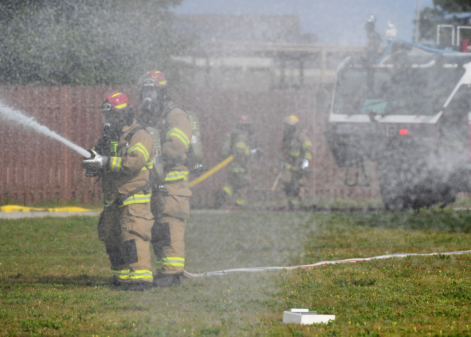 Keesler firefighters simulate putting out a fire as they arrive on scene during a mass casualty and response exercise on Keesler Air Force Base, Mississippi, April 17, 2019. The scenario for the two-day event included a simulated plane crash with debris landing both on and off base in crowds of people. The exercise tested base and local civilian emergency response organizations' ability to operate in a multi-agency and multi-jurisdiction crisis situation. (U.S. Air Force photo by Kemberly Groue)