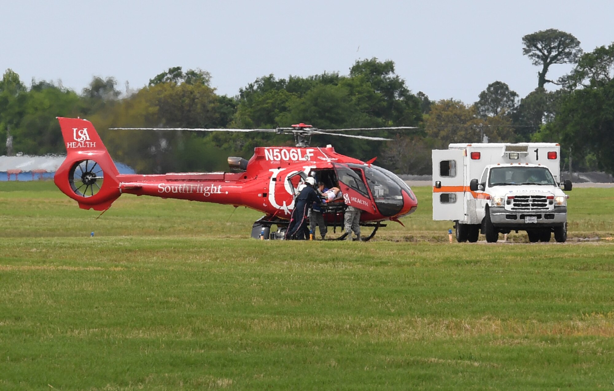 Members of the 81st Medical Group transports a "victim" onto the University of South Alabama Medical Center SouthFlight Helicopter during a mass casualty and response exercise on Keesler Air Force Base, Mississippi, April 17, 2019. The scenario for the two-day event included a simulated plane crash with debris landing both on and off base in crowds of people. The exercise tested base and local civilian emergency response organizations' ability to operate in a multi-agency and multi-jurisdiction crisis situation. (U.S. Air Force photo by Kemberly Groue)
