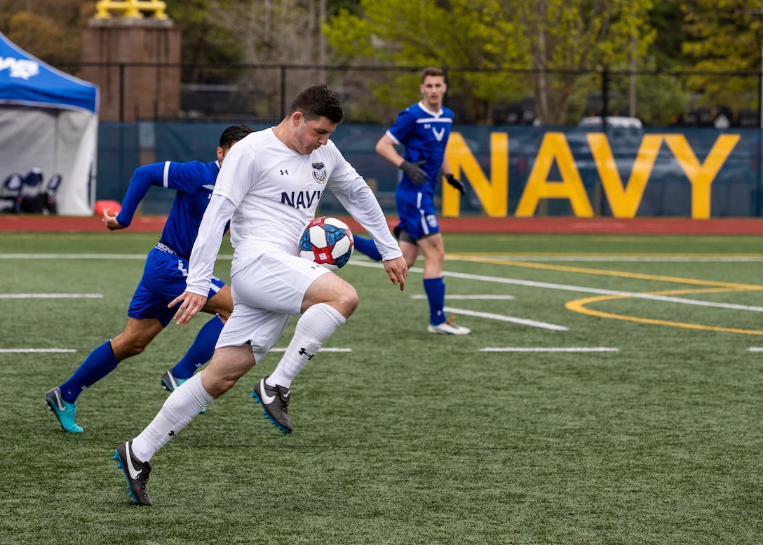 NAVAL STATION EVERETT, Wa. (April 18, 2019) - Seaman Daniel Galvin, stationed at Naval Weapons Station Earle, N.J., drives the ball past defenders from the Air Force soccer team at the Armed Forces Sports Men’s Soccer Championship hosted at Naval Station Everett. (U.S. Navy Photo by Mass Communication Specialist 2nd Class Ian Carver/RELEASED).