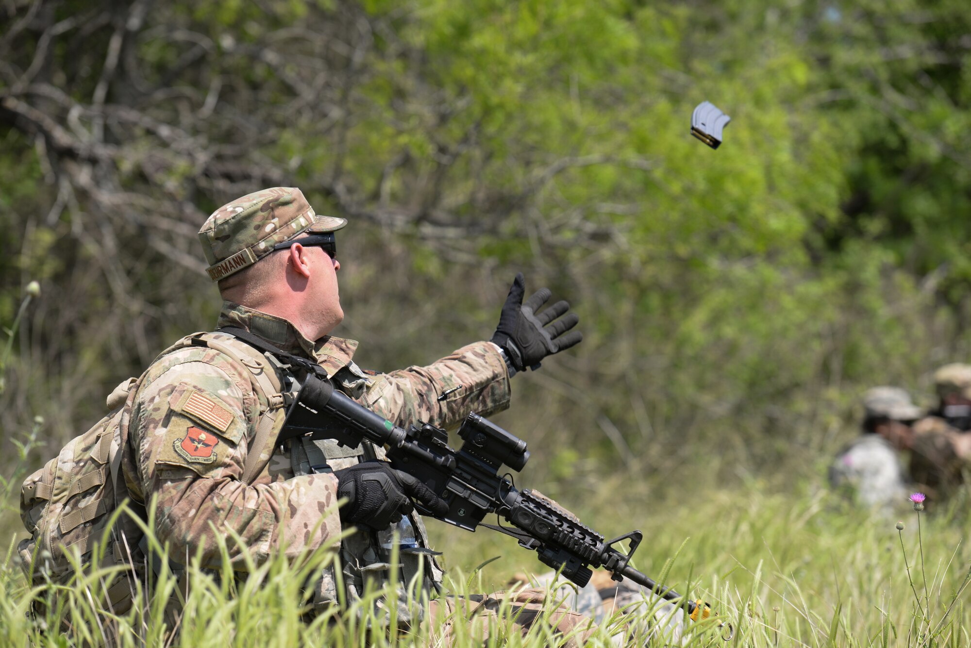 Staff Sgt. Codey Doehrmann, 47th Security Forces Squadron military working dog handler, catches a fresh magazine during an exercise at Laughlin Air Force Base, Texas, April 17, 2019. As the exercise drew near its end, so did many of the ammo pouches Laughlin’s Defenders depended on, but Doehrmann could count on his wingmen. (U.S. Air Force photo by Senior Airman Benjamin N. Valmoja)