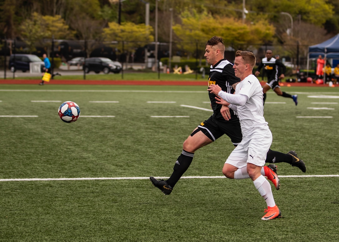 NAVAL STATION EVERETT, Wash. (April 18, 2019) -- Marine Lance Corporal Nicholas Heath (White Jersey) of Camp Lejeune, N.C. races downfield against Army during the 2019 Armed Forces Men's Soccer Championship.  (U.S. Navy Photo, MC2 Ian Carver/Released)